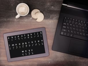 a tablet computer sitting on top of a wooden table.