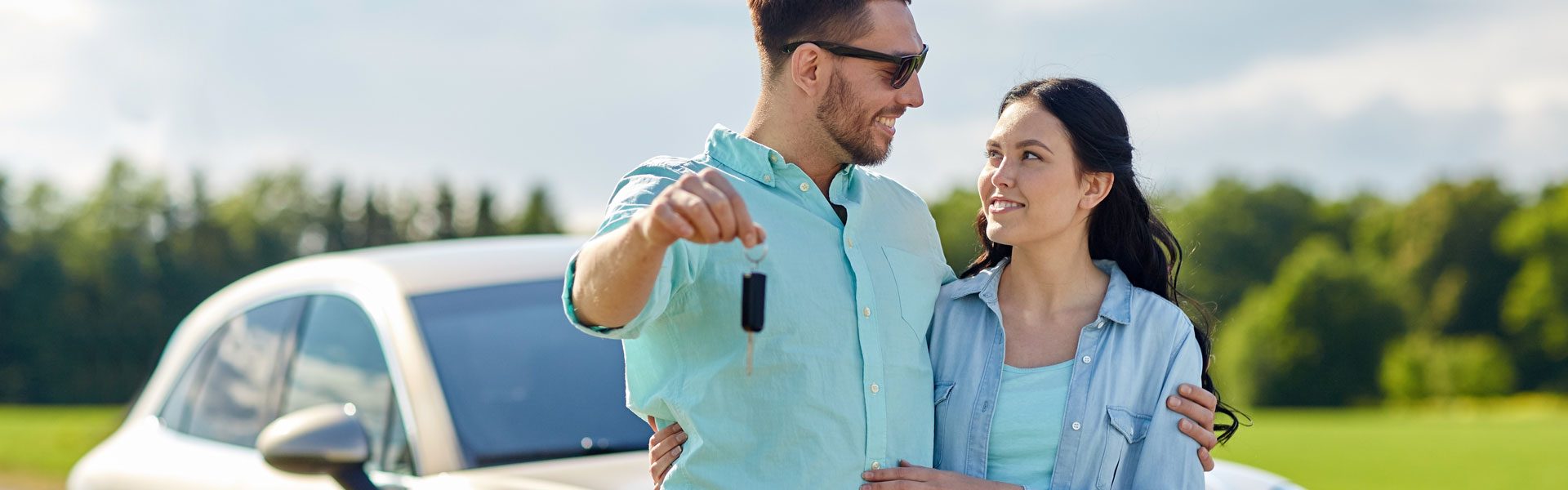 a man and a woman standing next to a car.